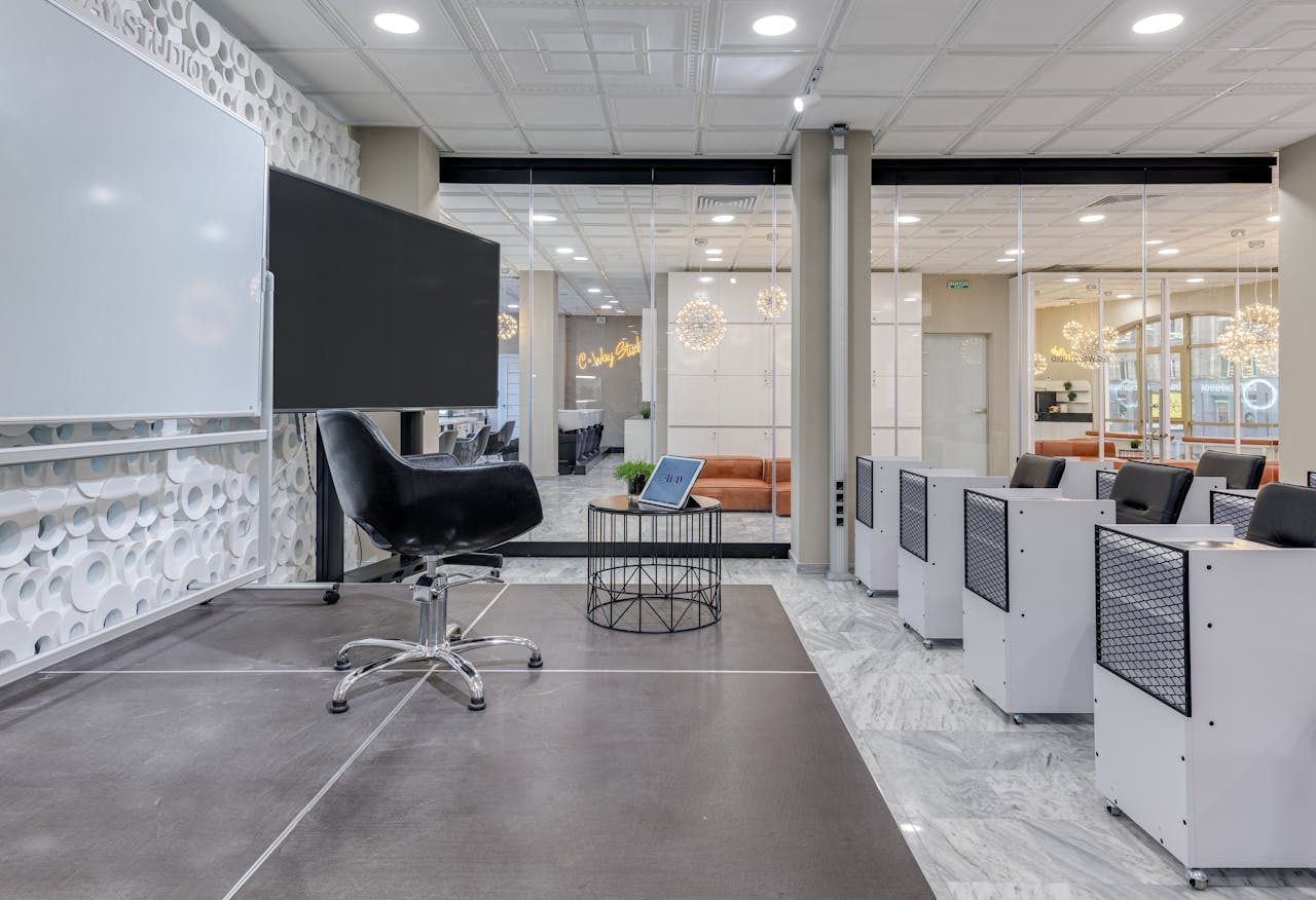 A contemporary conference room with chairs, screens, and presentation boards.